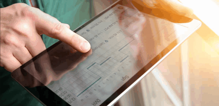 Close-up of hands using a digital tablet to review electronic driver logs and scheduling data.