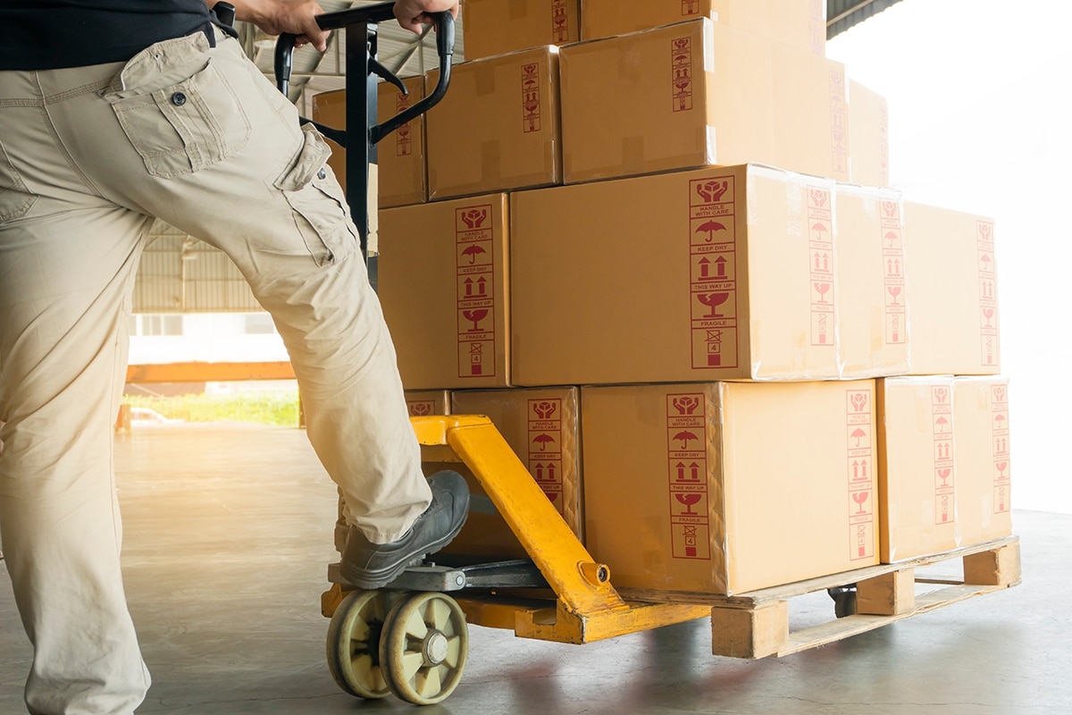 What is LTL Freight man with a pallet jack pushing a pallet full of boxes