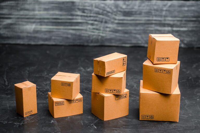 Stacks of miniature cardboard shipping boxes arranged in an ascending step pattern resembling a growth chart, symbolizing e-commerce fulfillment scaling and increasing parcel volumes Exploring Cost to Serve in Your Supply Chain Operations