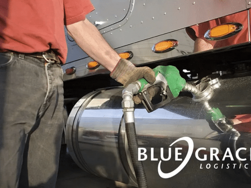 Close-up of a truck driver pumping diesel fuel into a semi-truck's chrome tank