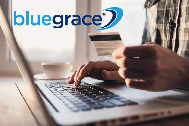 Close-up of a person using a laptop and holding a credit card for an online transaction.