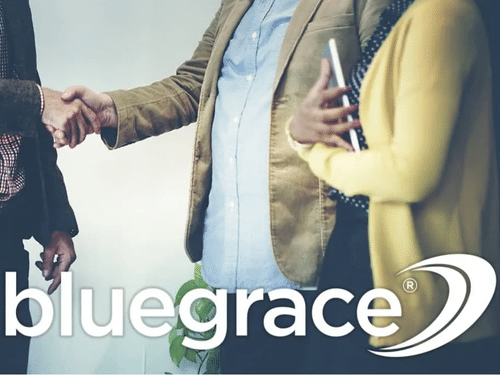 Close-up of professionals shaking hands in an office setting with the BlueGrace logo.