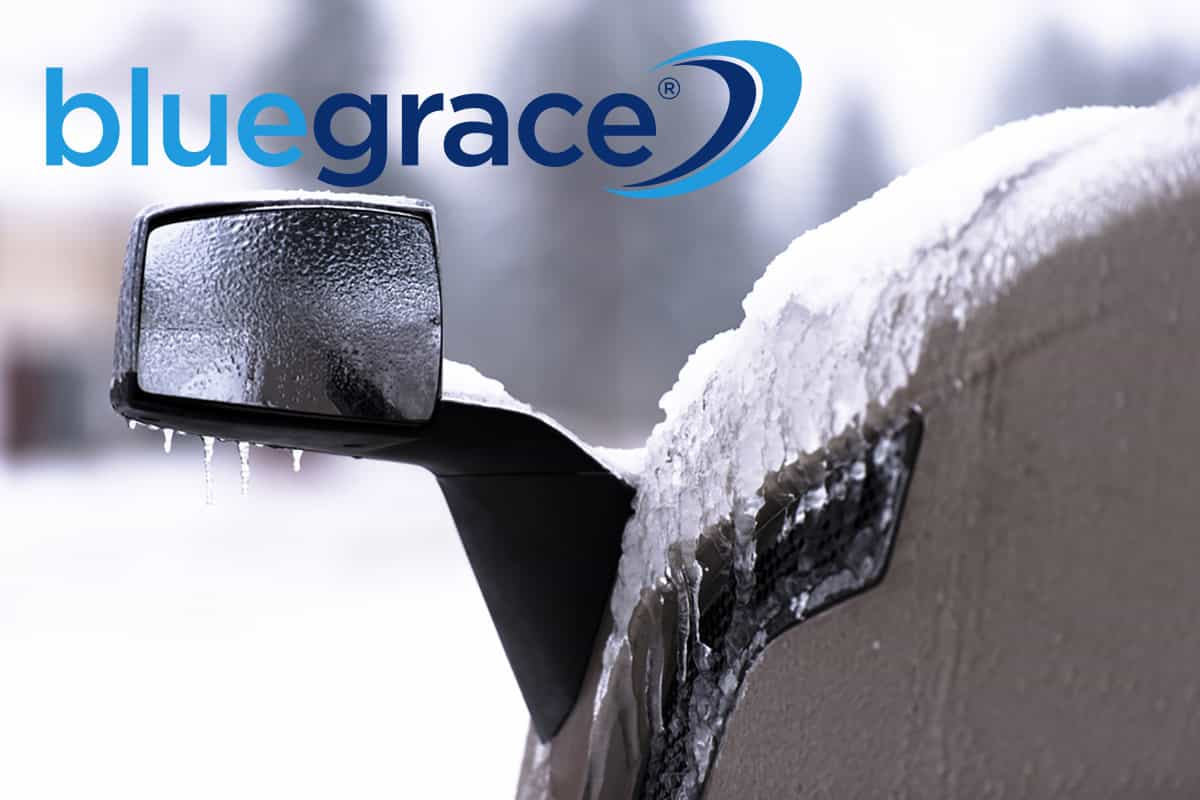 Close-up of a truck side mirror covered in ice and icicles with the BlueGrace logo.