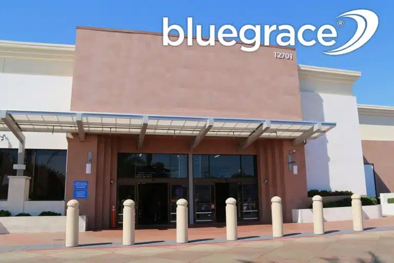 BlueGrace logo over the modern glass and stone entrance of a commercial office building.