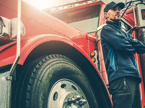 truck driver standing near red truck