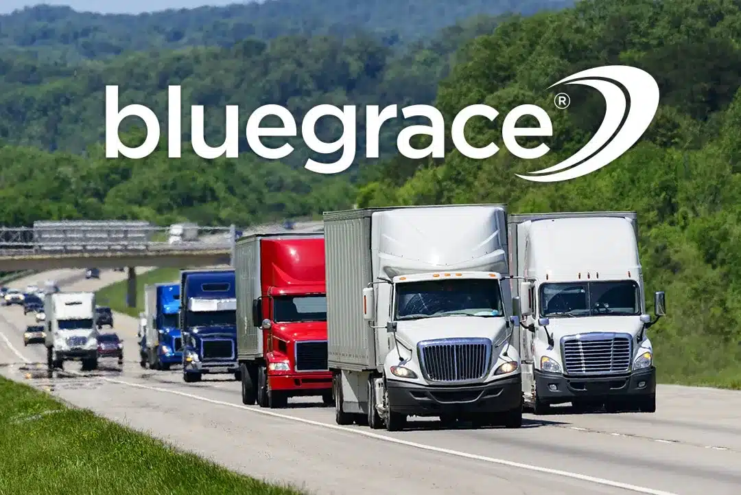 A line of semi-trucks driving on a highway through a green landscape with the BlueGrace logo.