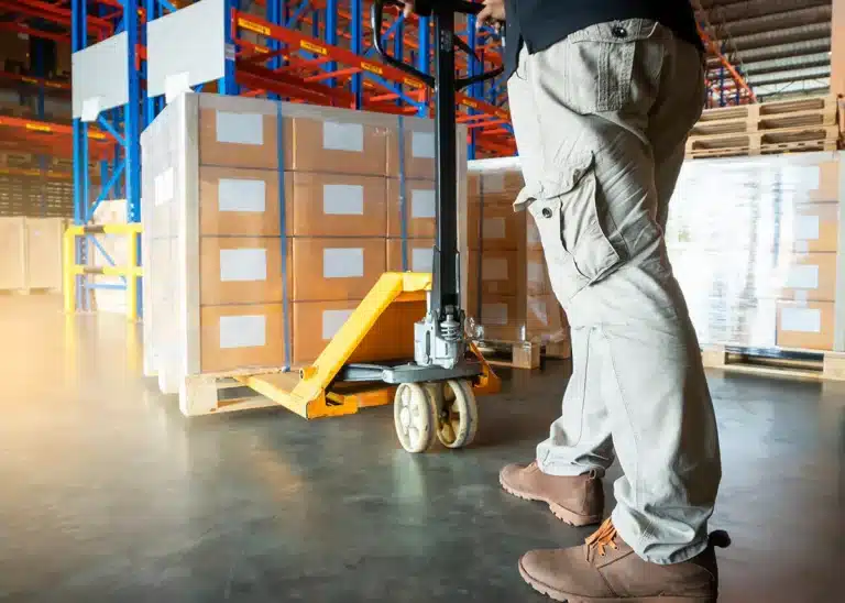 LTL vs FTL man pulling pallet jack in a loading dock