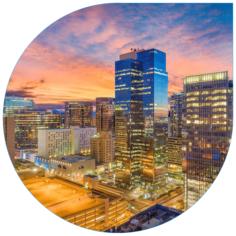 Vibrant sunset aerial view of the Phoenix urban skyline featuring modern glass skyscrapers, city streets, and architectural lighting.