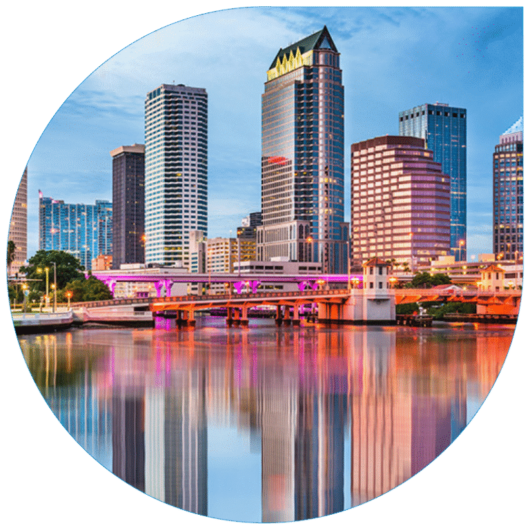 Vibrant evening view of Tampa city skyline reflecting in the water, representing a central urban hub for regional commerce and logistics connectivity.