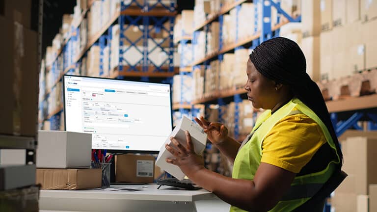 Woman staff managing package labeling using shipment details adhesive tags