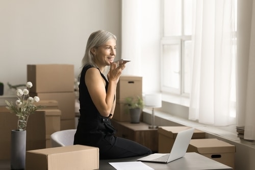 Ecommerce Logistics Solutions woman calling on her cellphone surrounded by packages that need to be sent