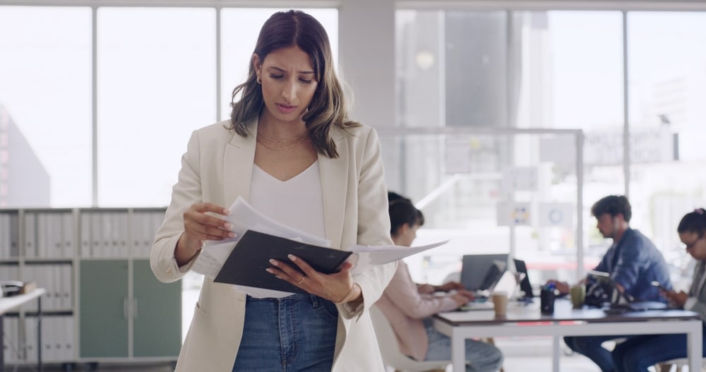 Worker reviewing folder for freight audit and supply chain management
