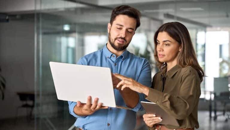Operating Partner Logistics Playbook two business people look at data on laptop