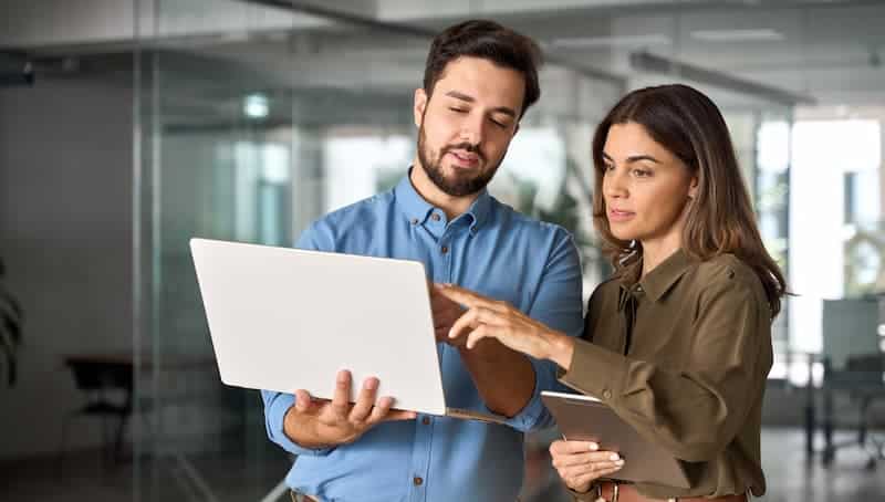 Operating Partner Logistics Playbook two business people look at data on laptop