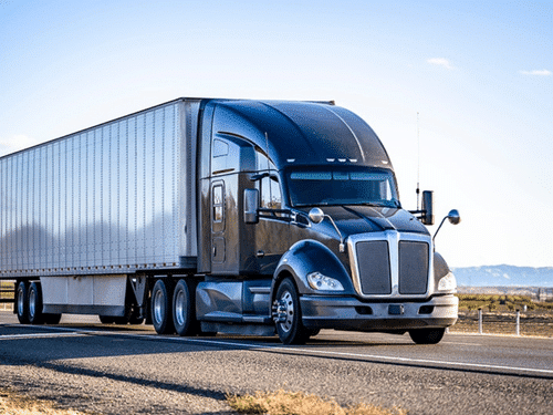 Blue semi truck with white trailer representing dry van freight transportation